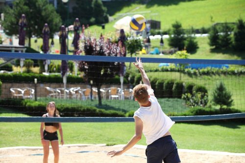 Hráči na beach volejbalovom ihrisku v areáli hotela